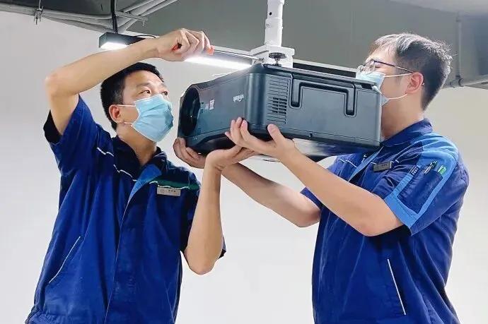 Technicians installing a flying theater projector