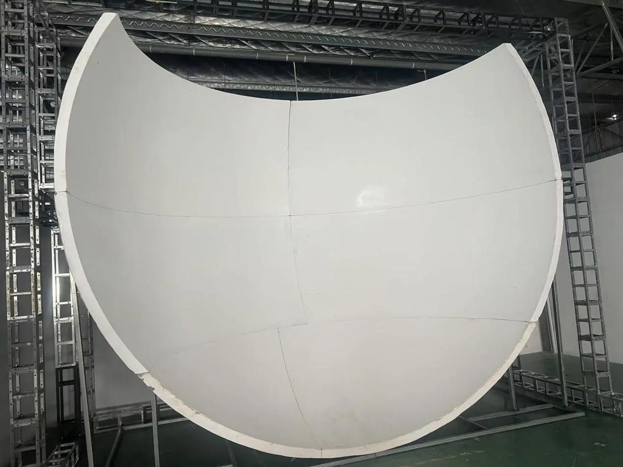 Flying theater screen panel installation in a production facility